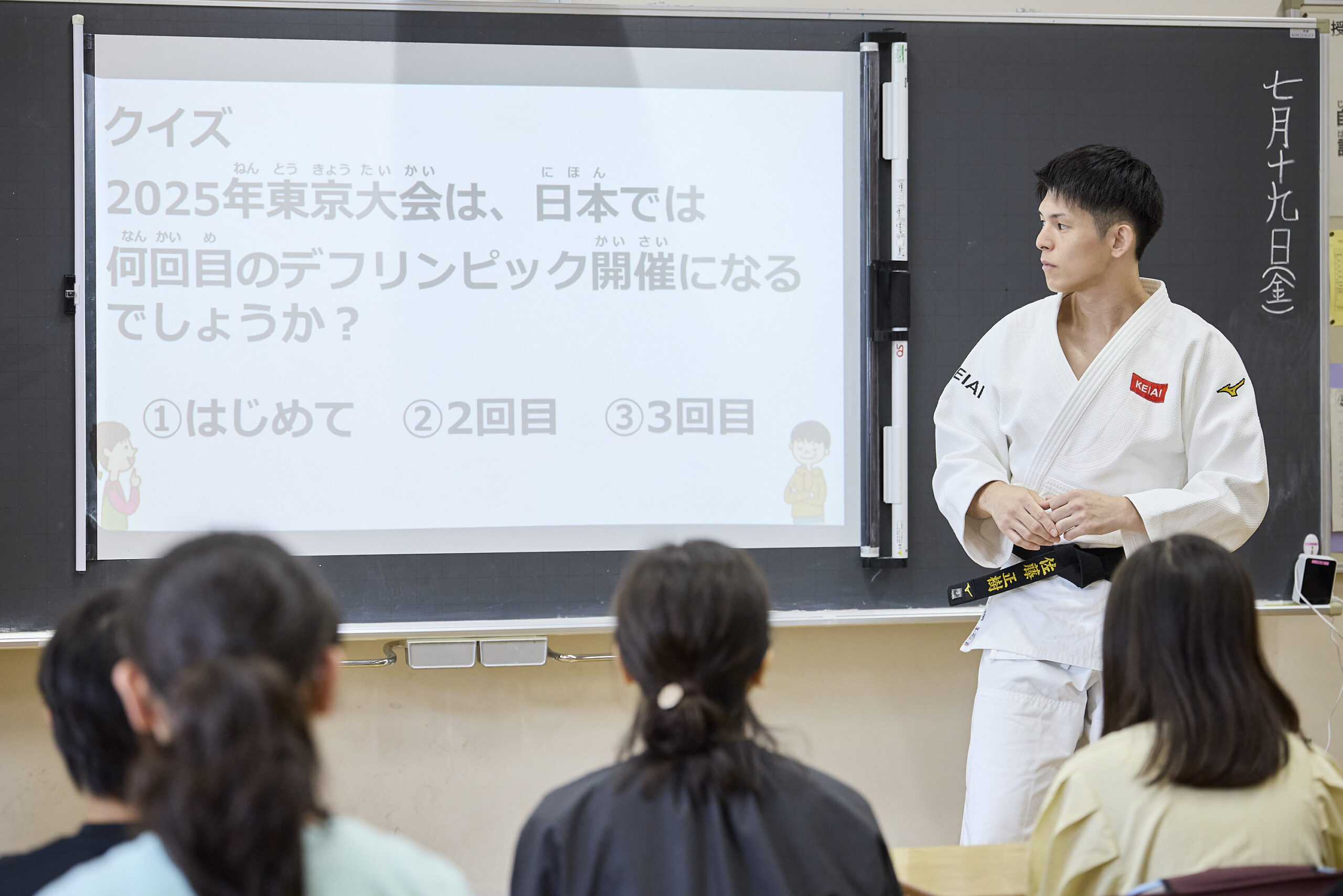クイズが表示されているスクリーンをみつめている佐藤選手の写真