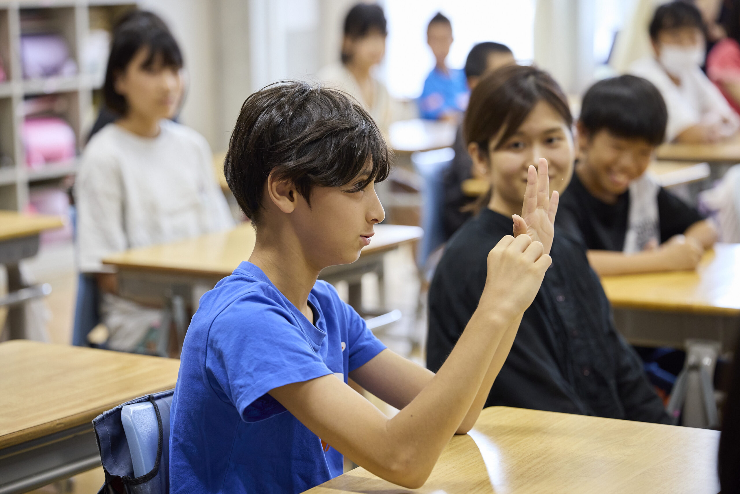 手話で何かを伝えている児童の写真