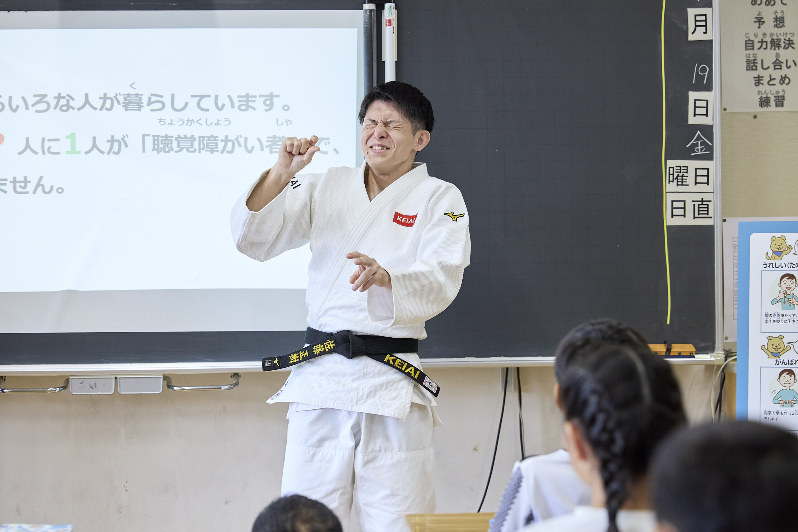 右手で少しを作り、顔をしかめている佐藤選手の写真