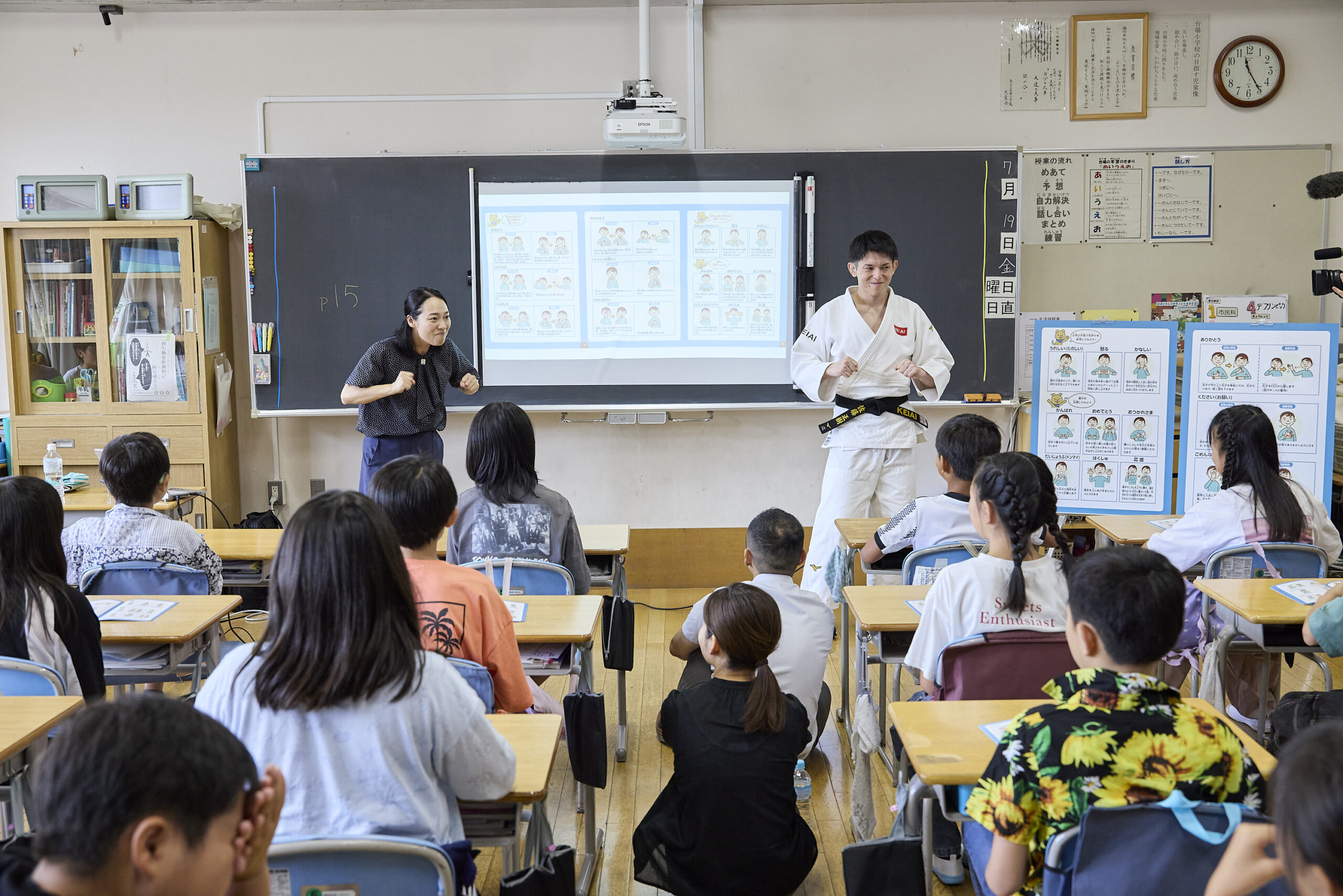 拳を作り両腕を脇に置いてポーズをとっている川俣さんと佐藤選手の写真