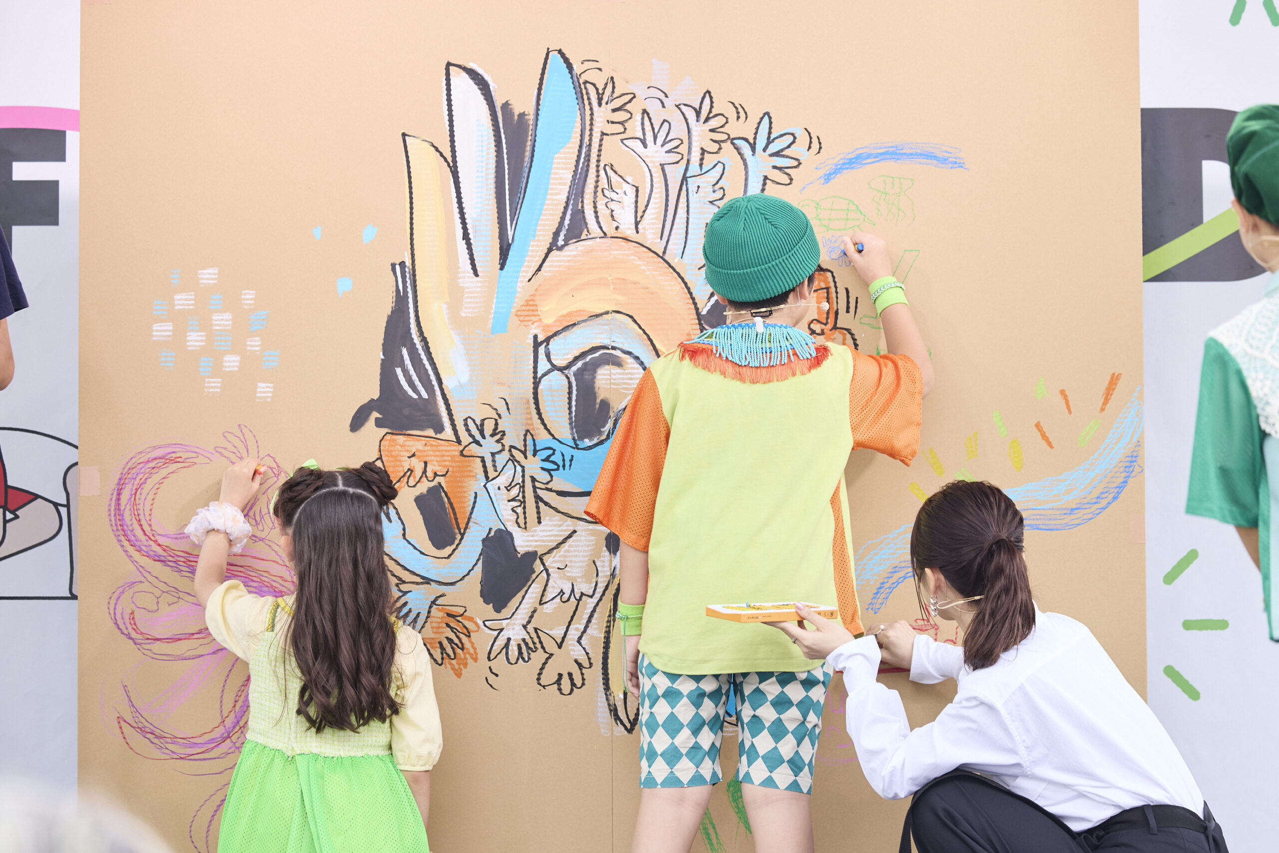 ミドリーズの二人と長濱さんが壁に絵を描いている写真