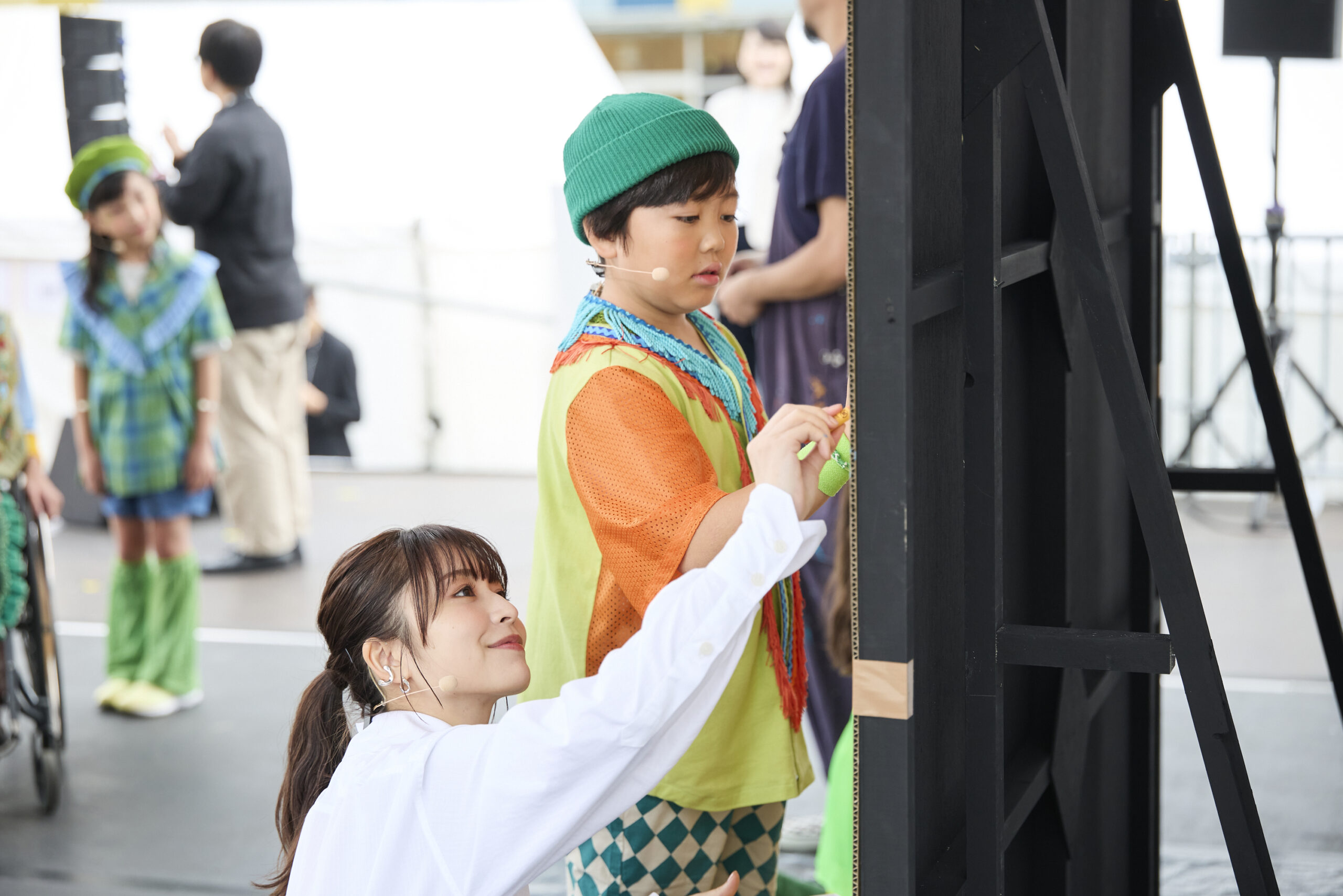 長濱さんとミドリーズの子供が壁に絵を描いている写真