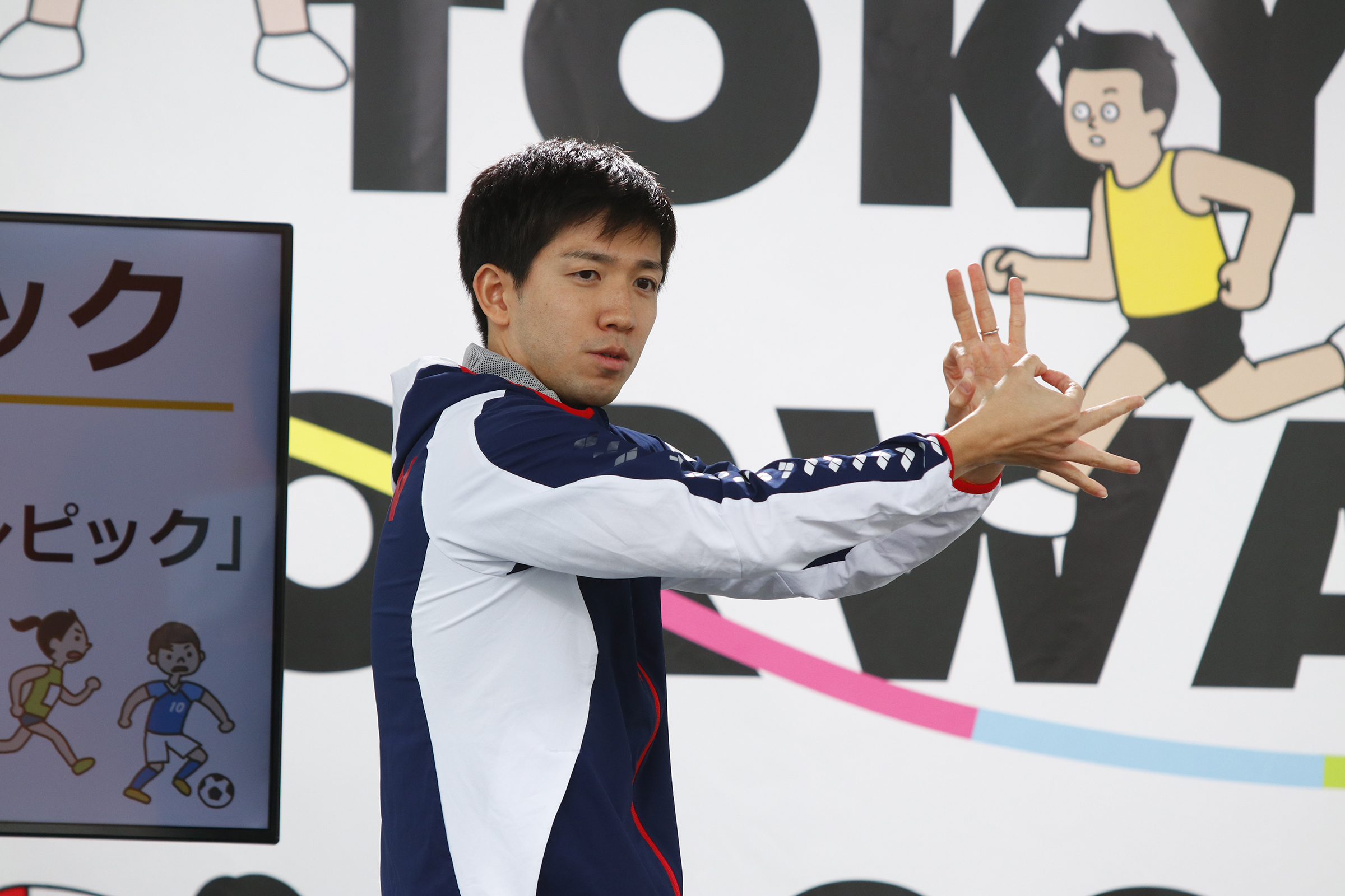 茨選手が手話で説明している写真