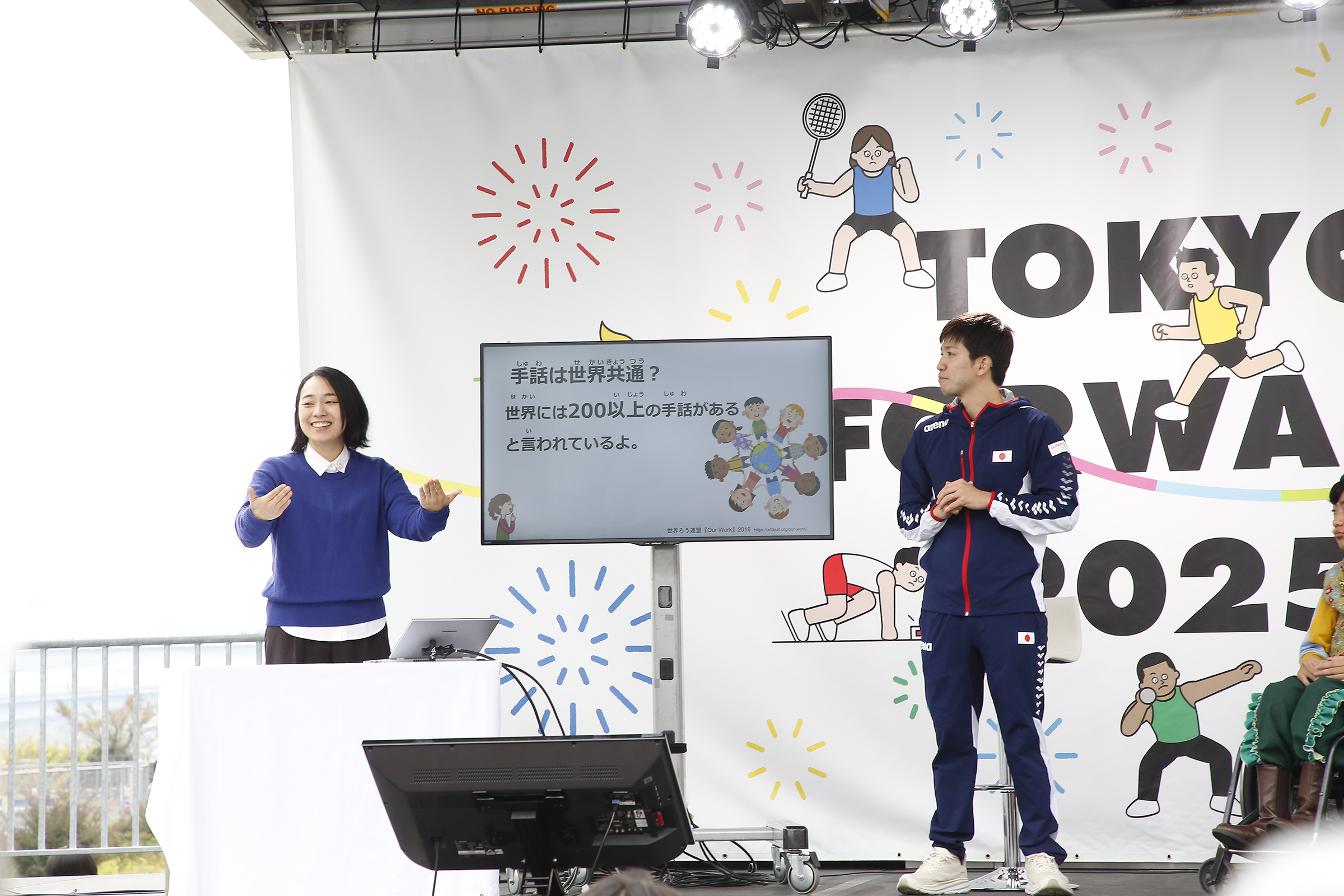 川俣さんと茨選手が手話で説明している写真