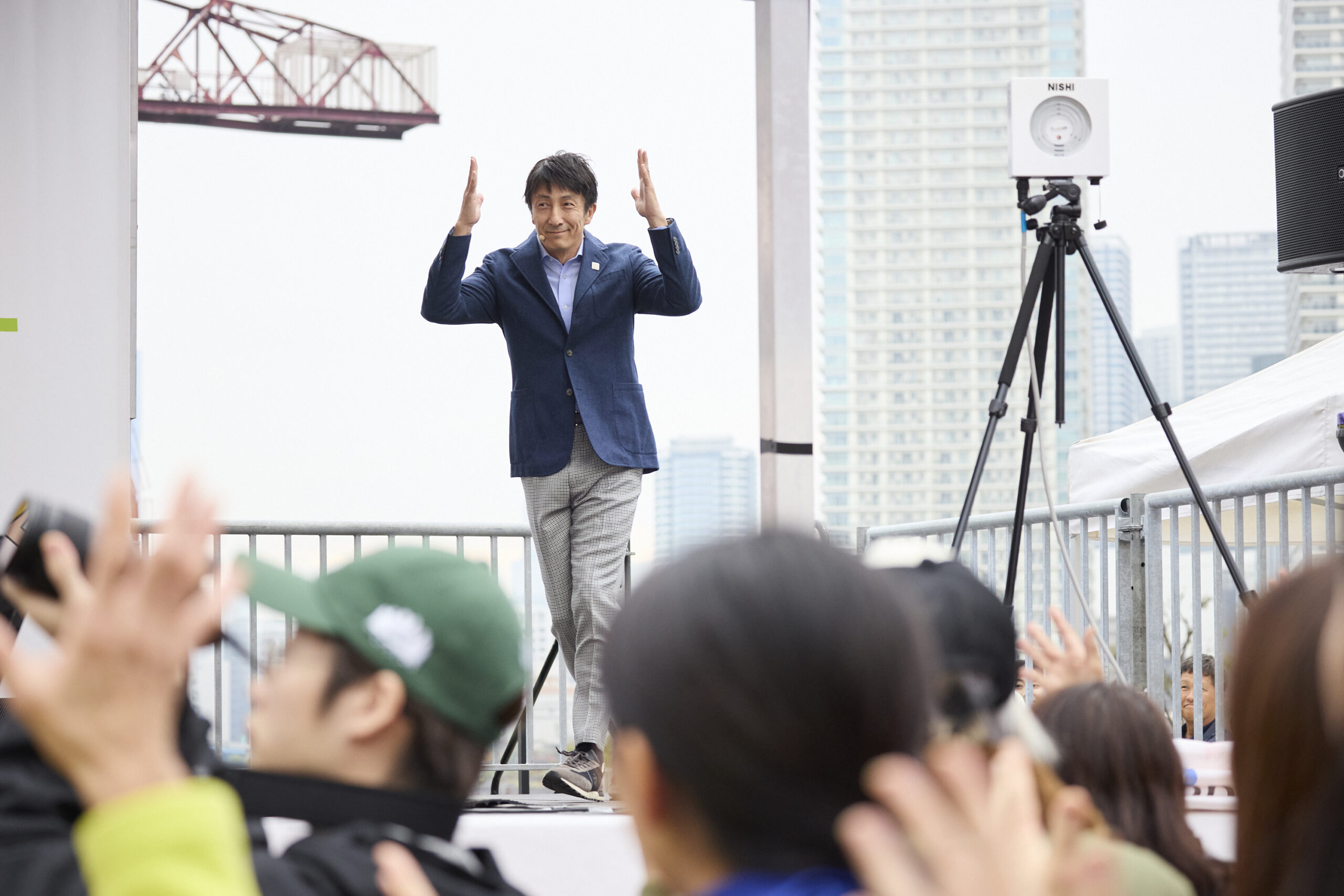 朝原さんが拍手の手話で壇上に登場している写真