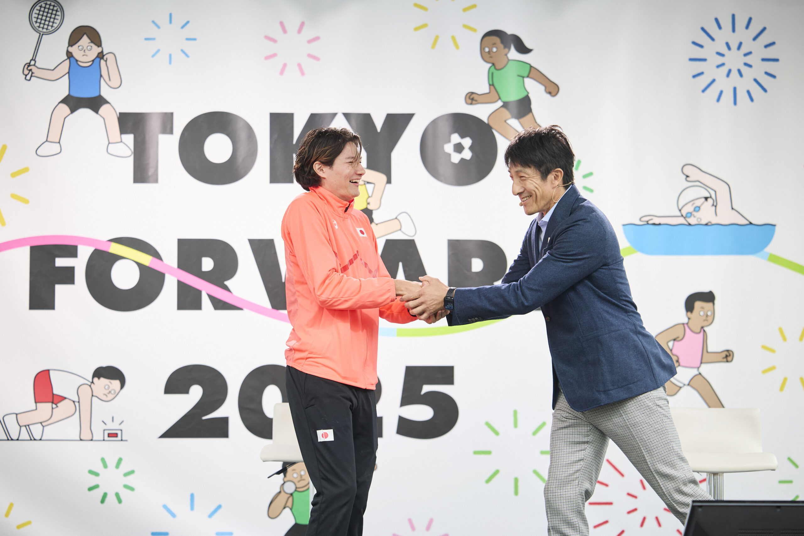 山田選手と朝原さんが握手をしている写真