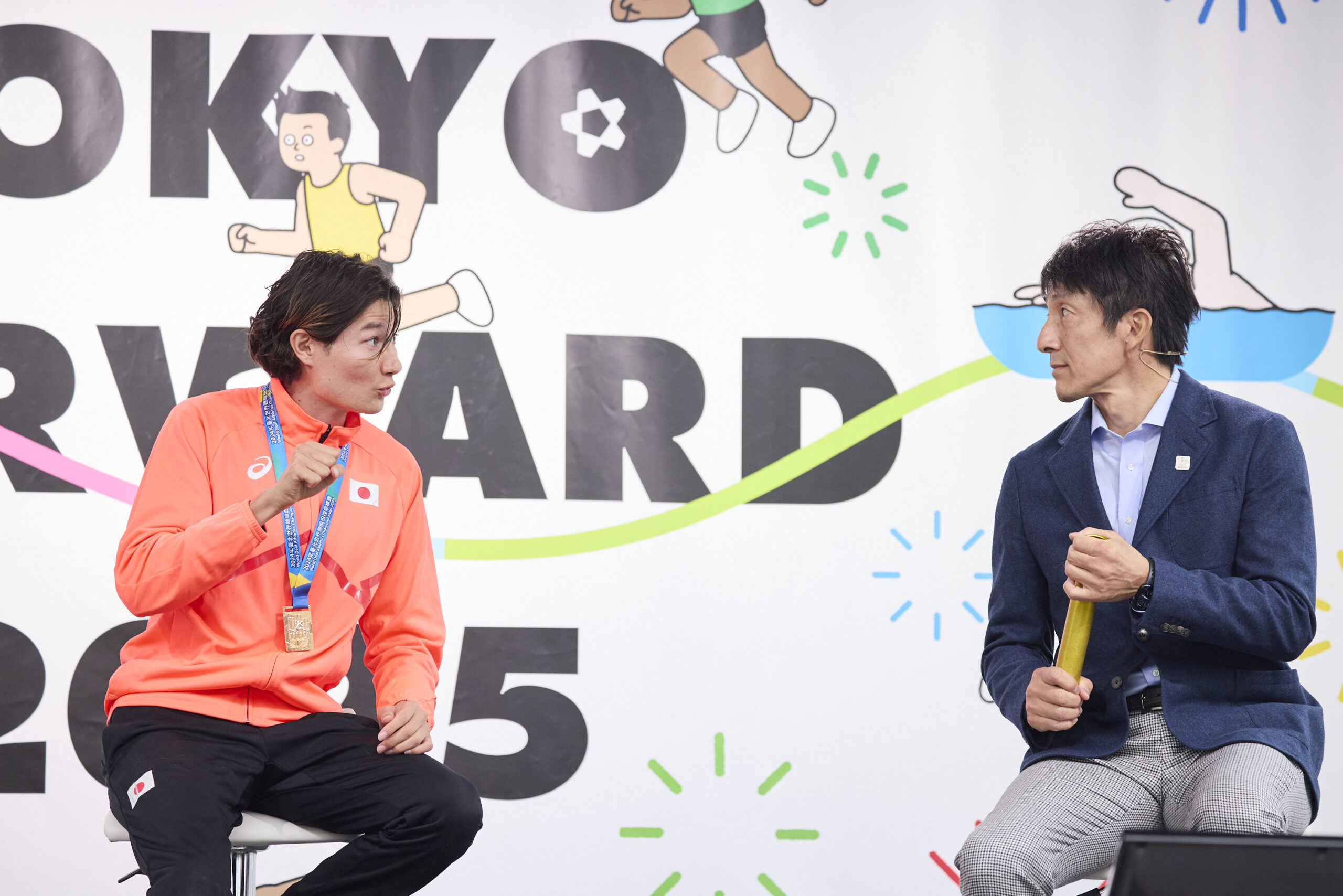 山田選手が朝原さんに手話で話しかけている写真