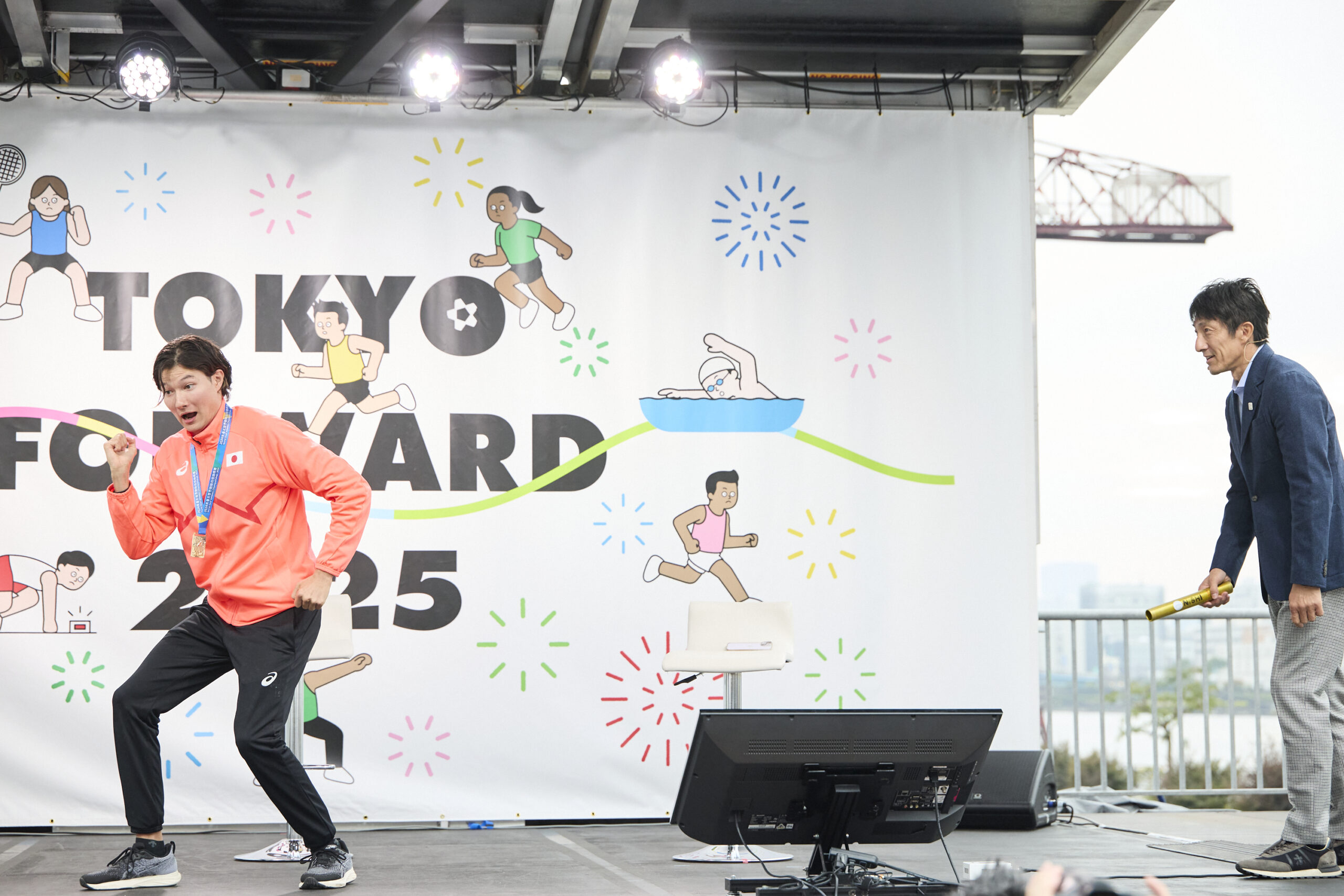 走る構えをしている山田選手と、バトンを持っている朝原さんの写真