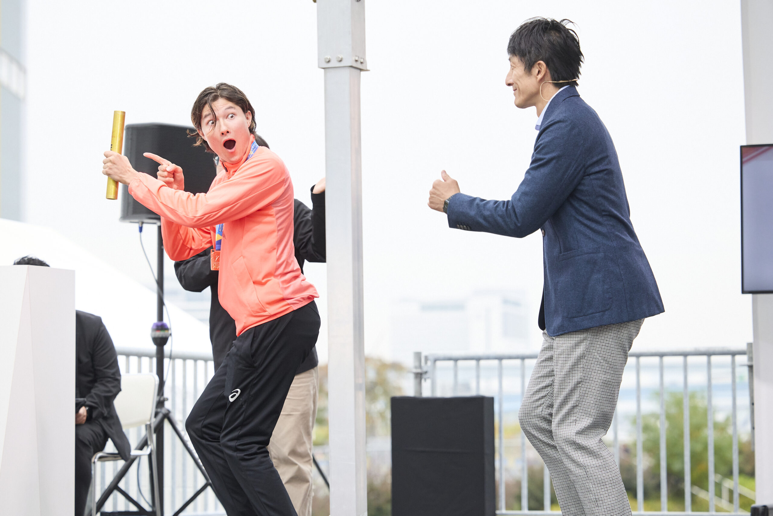 山田選手がバトンを指さして受け取ったことを確認し、朝原さんに伝えている写真