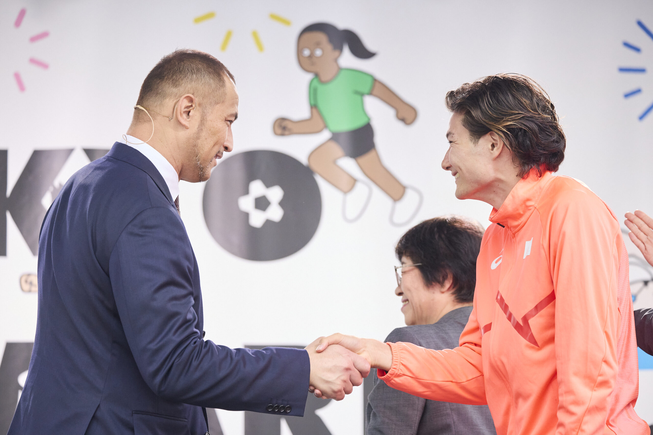 室伏さんと山田選手が握手をしている写真