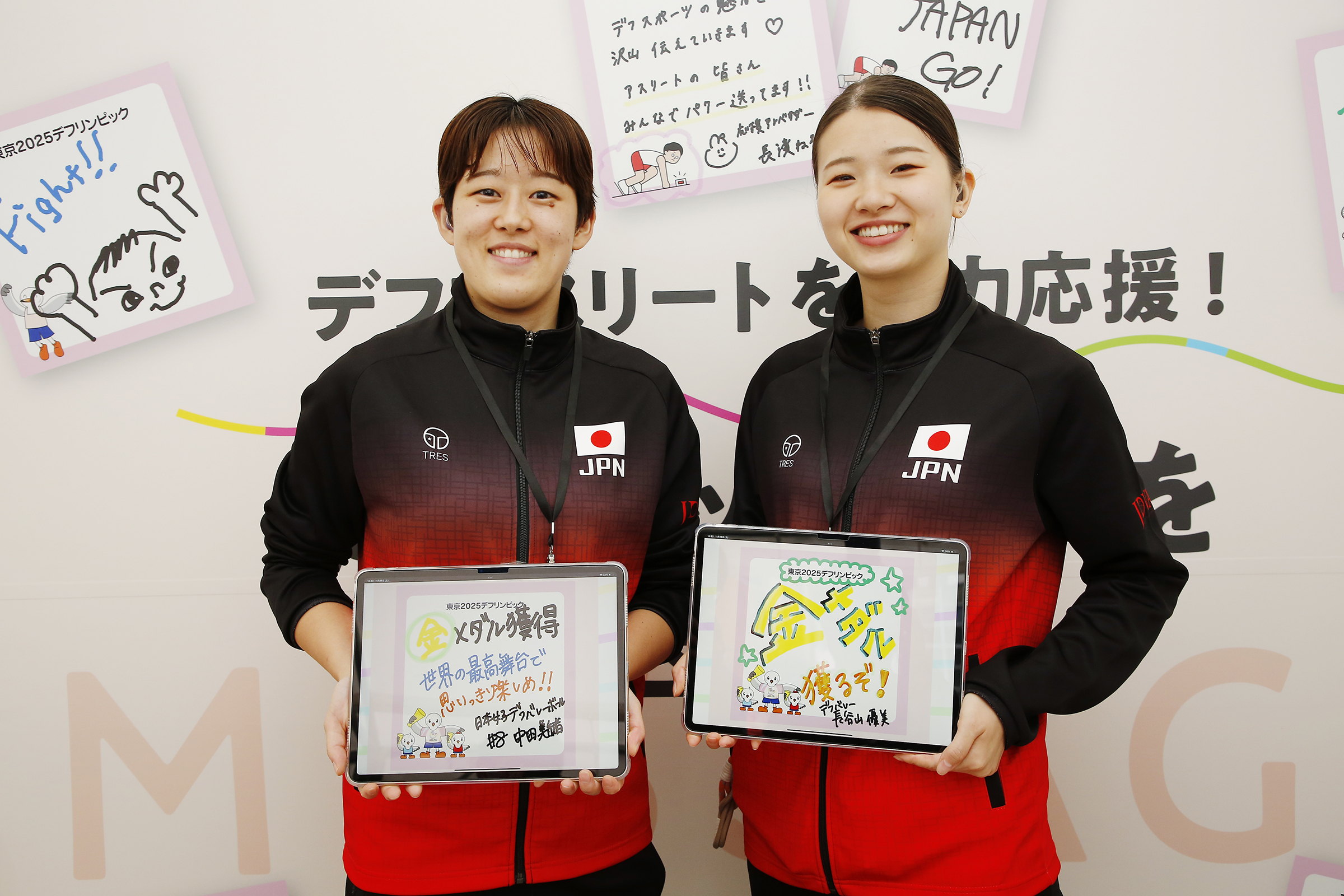 メッセージを書いたタブレットを持っている中田選手と長谷山選手の写真