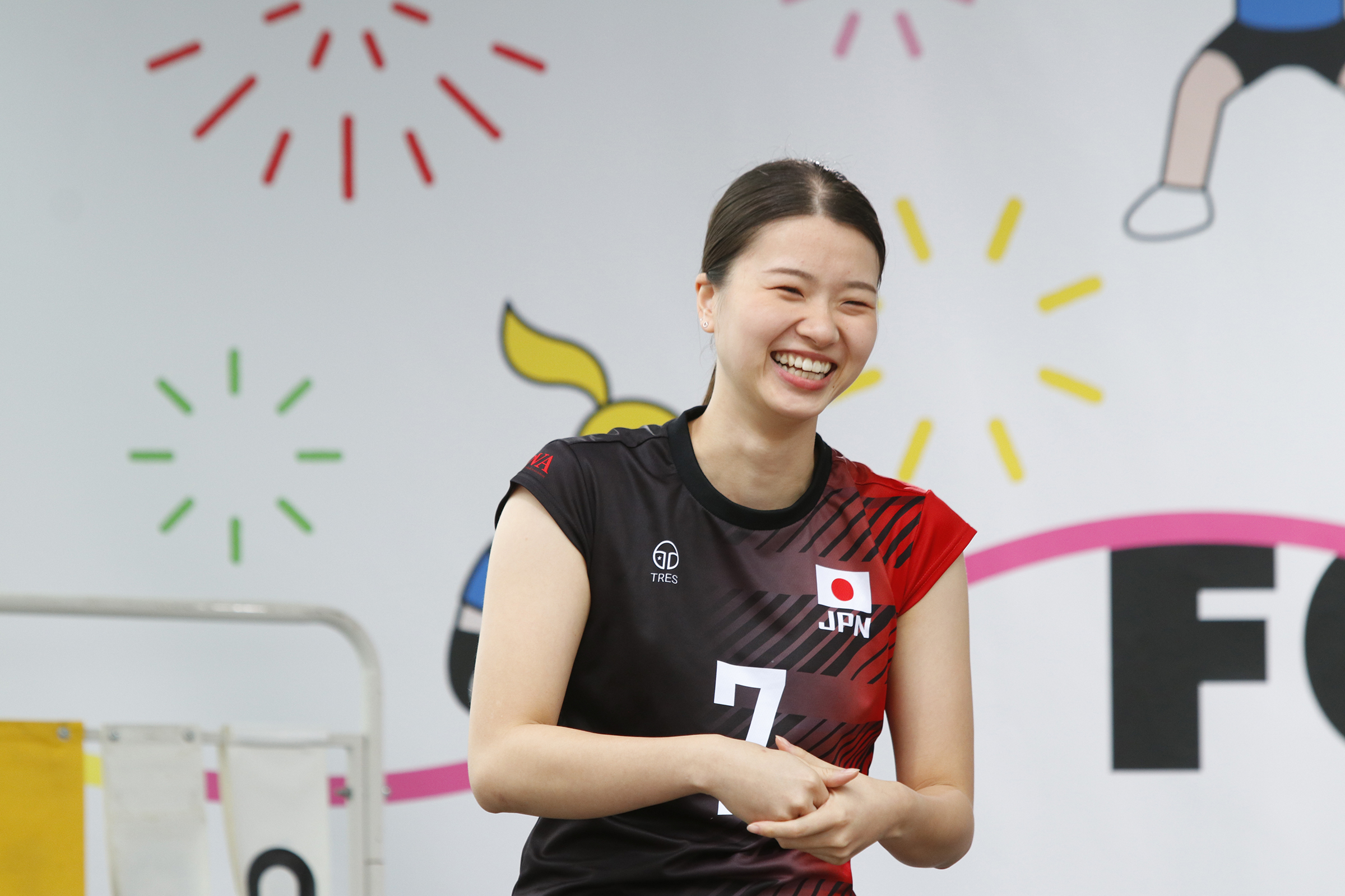 壇上で笑っている長谷山選手の写真
