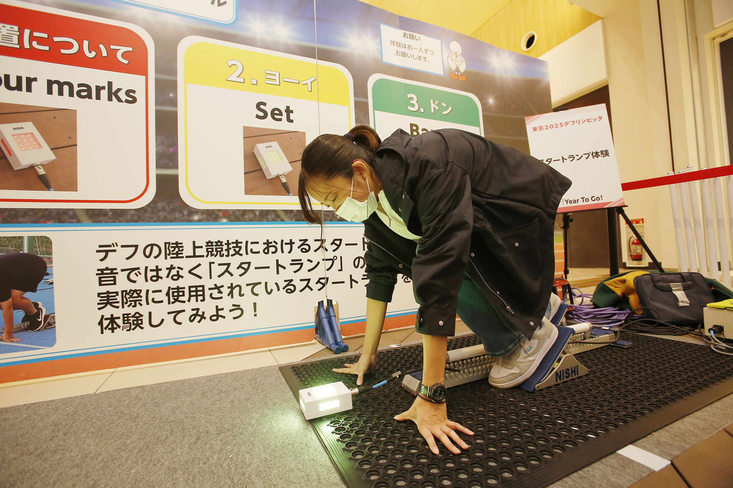 陸上のスタートランプとクラウチングスタートの姿勢の女性の写真
