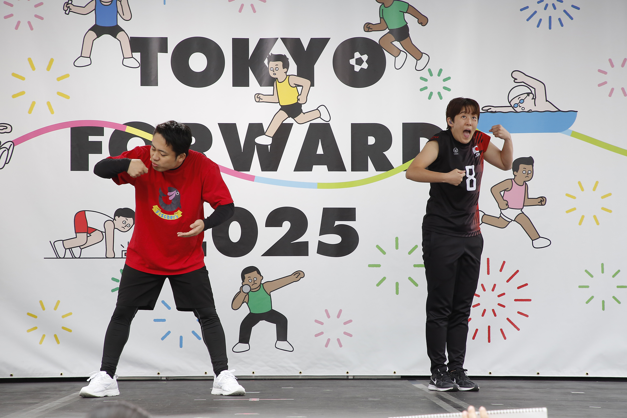 何かを食べているようなジェスチャーのシルクロードさんと腕を胸の前にし大きく口を開けている中田選手の写真