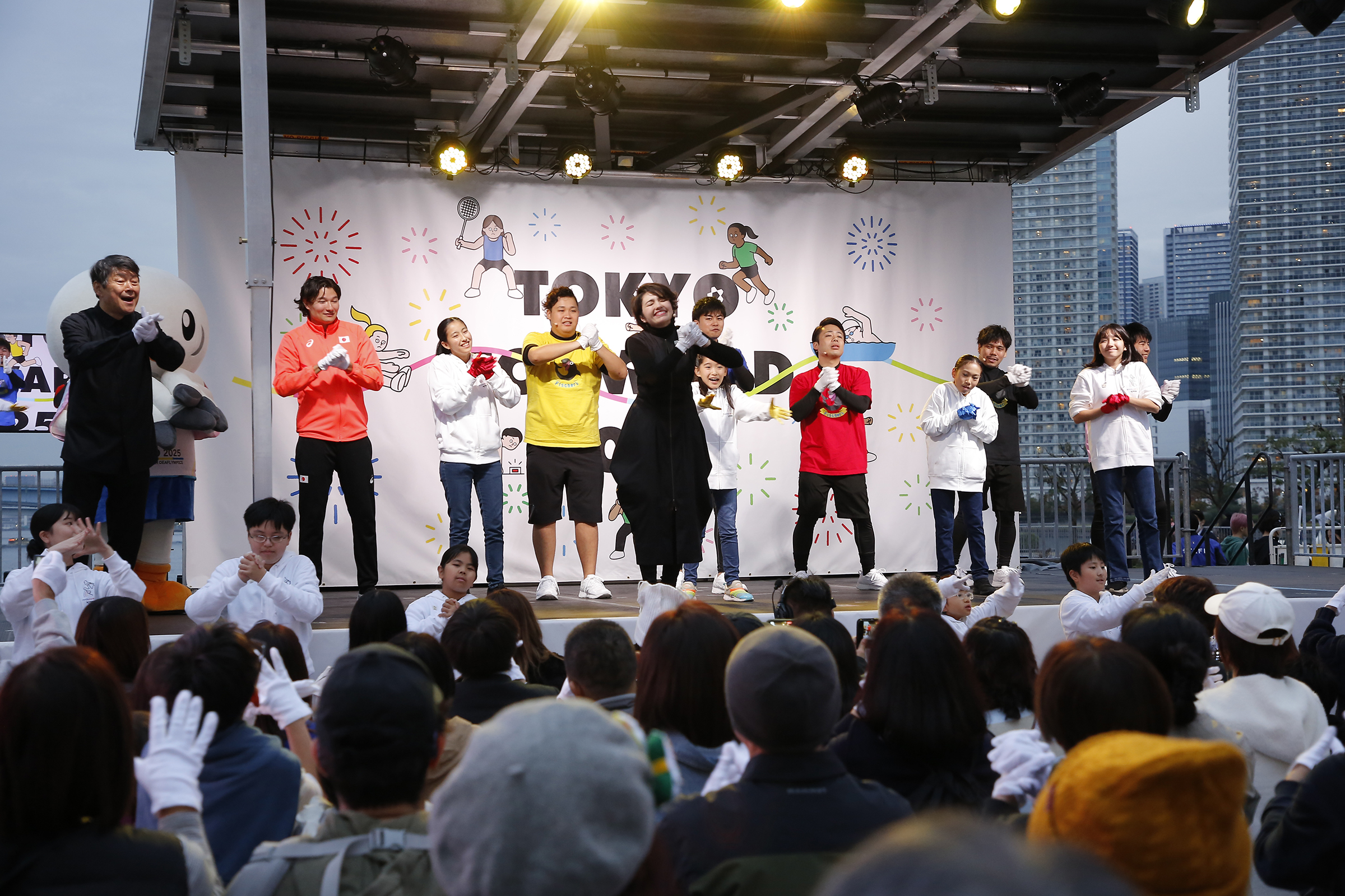 手歌をしているフィッシャーズ、山田選手、ホワイトハンドコーラスNIPPONの数名、コロンさん、井崎さんの写真