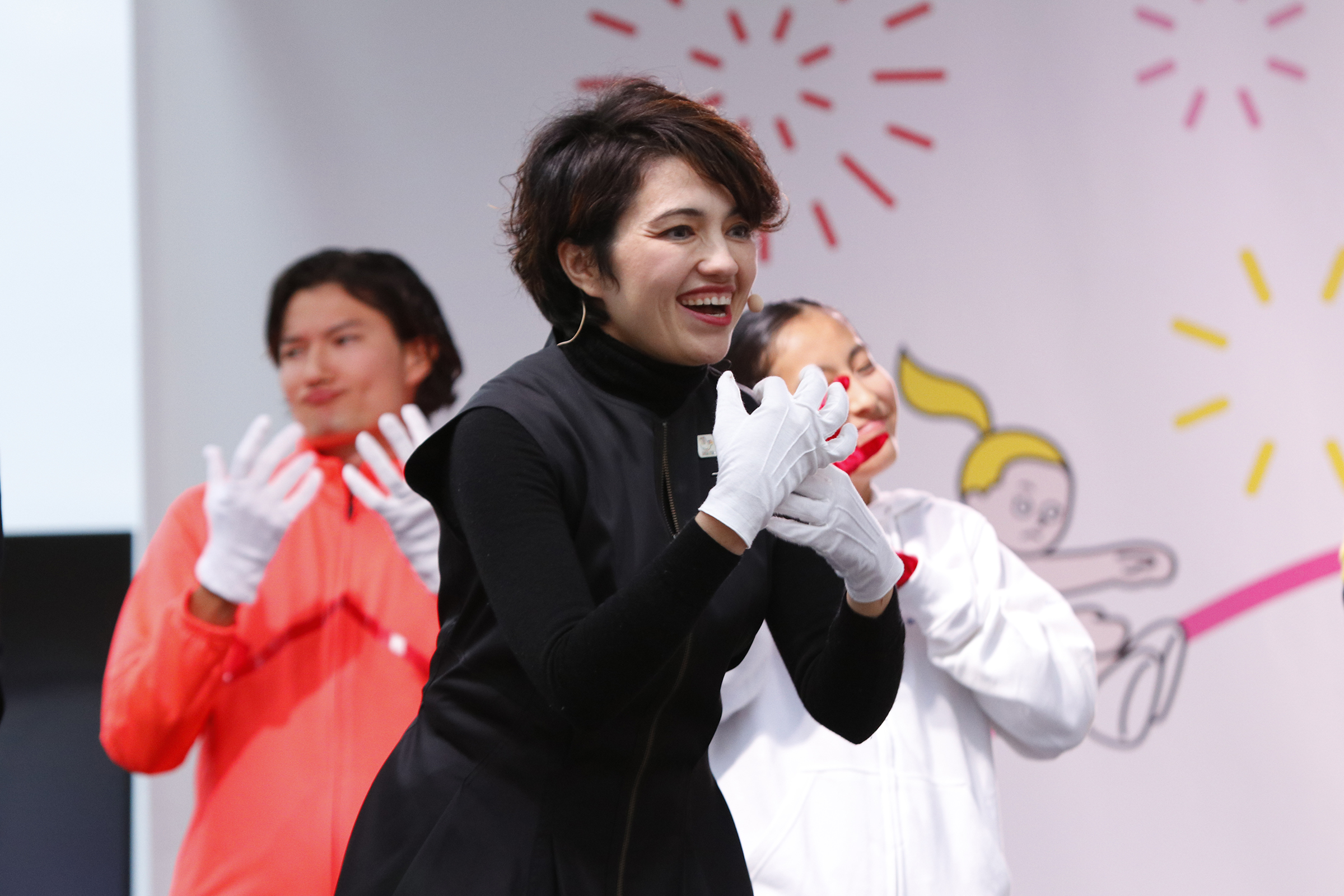 両手を胸の前に置き微笑んでいるコロンさんの写真