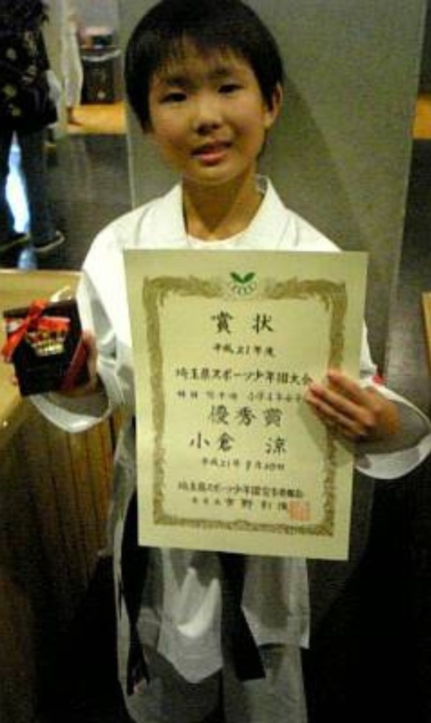 表彰状と表彰楯を持っている小学生時代の小倉選手の写真