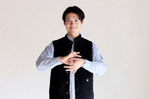 笑顔で手話をしている保科さんの写真