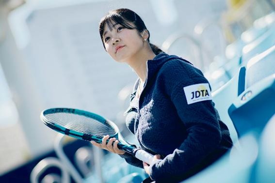 ラケットを握り、遠くを見つめている菰方選手の写真